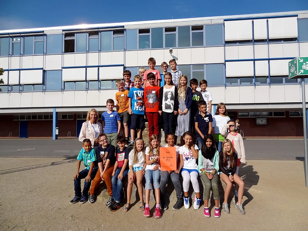 Klassenfoto einer neuen fünften Klasse auf dem Schulhof.